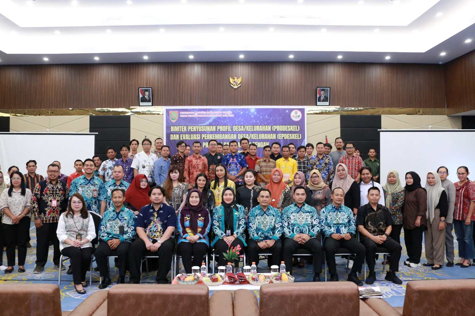 Seorang pejabat Dinas PMD Kalteng memberikan sambutan dalam Bimtek PRODESKEL dan EPDESKEL 2025 di Ballroom Alltrue Hotel Palangka Raya, diikuti oleh peserta dari berbagai desa dan kelurahan.